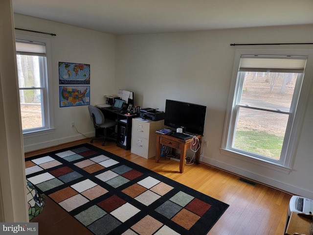  - office space with wood finished floors, plenty of natural light, and baseboards