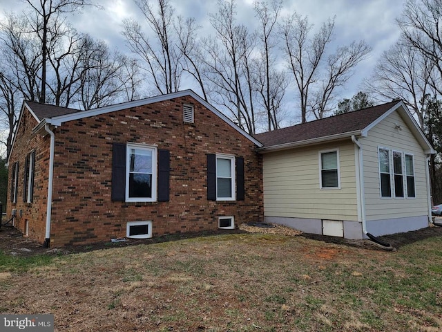  - rear view of house featuring a lawn and brick siding