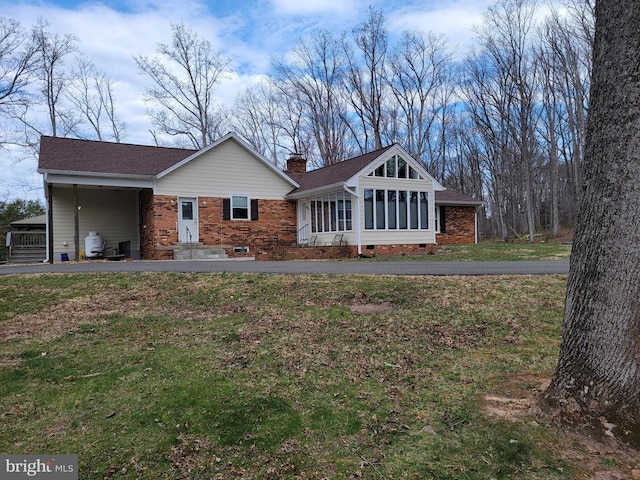 - single story home featuring a sunroom, a carport, crawl space, a front yard, and a chimney