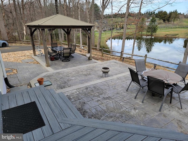  - view of patio / terrace with outdoor dining space, a water view, a gazebo, and fence