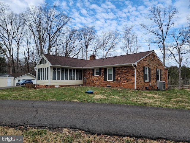  - single story home with a sunroom, crawl space, a chimney, a front lawn, and brick siding