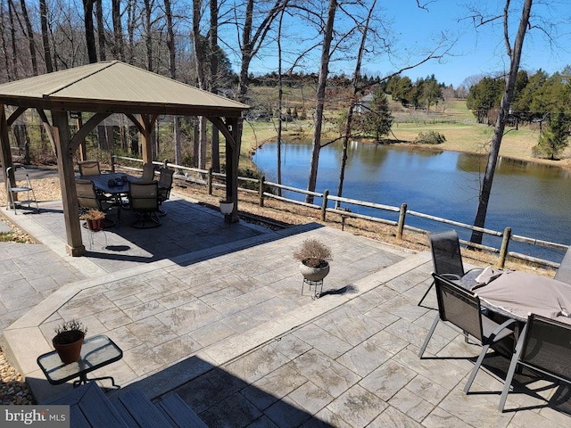  - view of patio with a gazebo, outdoor dining space, a water view, and view of scattered trees