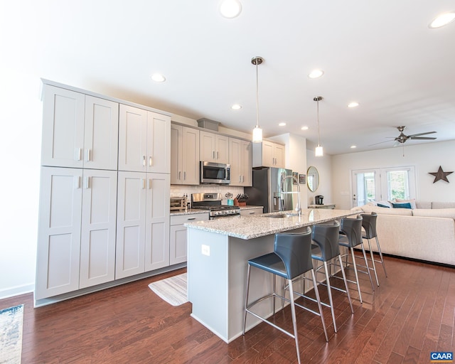 142 Junction Ln, Charlottesville, VA 22902 - kitchen featuring appliances with stainless steel finishes, a breakfast bar, a center island with sink, dark wood-style flooring, and recessed lighting