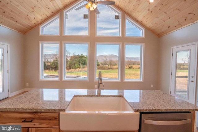 kitchen featuring a mountain view, sink, lofted ceiling, and light stone counters