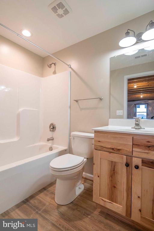 full bathroom featuring vanity, wood-type flooring, bathtub / shower combination, and toilet