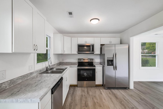 1114 Mountain View Dr, Harrisonburg, VA 22801 - kitchen featuring appliances with stainless steel finishes, light wood-style floors, white cabinetry, and light countertops
