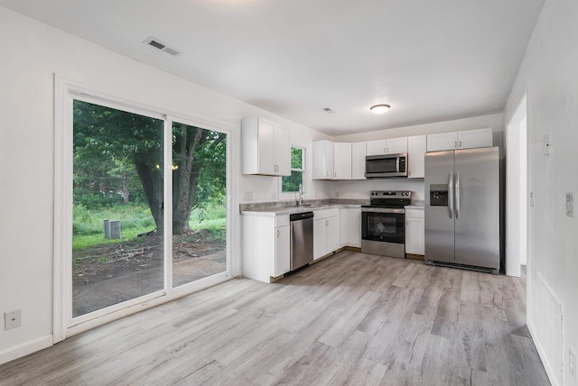 1114 Mountain View Dr, Harrisonburg, VA 22801 - kitchen with stainless steel appliances, light wood-style floors, light countertops, and white cabinets