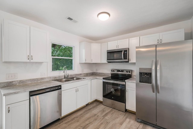 1114 Mountain View Dr, Harrisonburg, VA 22801 - kitchen with stainless steel appliances, white cabinetry, light wood-style flooring, and light countertops