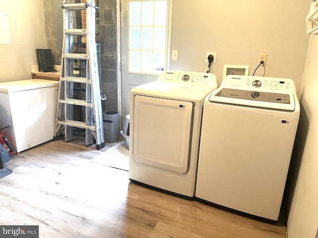  - washroom with washer and clothes dryer and light wood-style floors