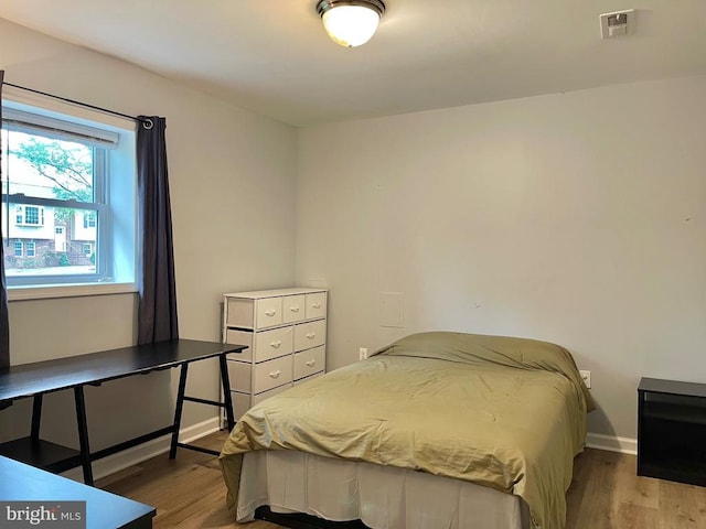  - bedroom with wood finished floors and baseboards