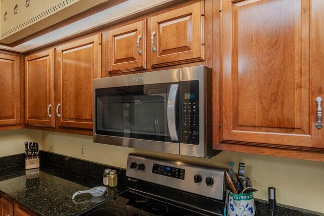 225 Divot Dr, Harrisonburg, VA 22802 - kitchen with stainless steel appliances, brown cabinetry, and dark stone countertops