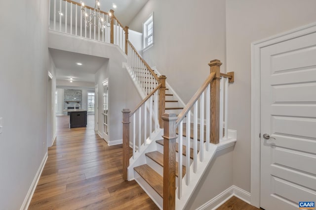 196 Thicket Run Pl, Charlottesville, VA 22911 - stairway featuring a chandelier, baseboards, and wood finished floors