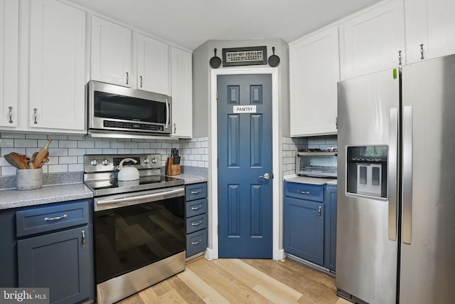 7329 Cloverhill Rd, Spotsylvania, VA 22551 - kitchen with appliances with stainless steel finishes, blue cabinetry, light wood finished floors, and white cabinetry