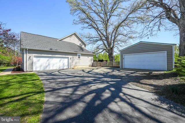 7329 Cloverhill Rd, Spotsylvania, VA 22551 - view of side of property featuring a detached garage, fence, an outdoor structure, and roof with shingles