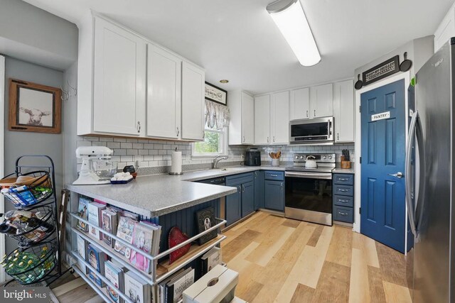 7329 Cloverhill Rd, Spotsylvania, VA 22551 - kitchen with stainless steel appliances, white cabinets, tasteful backsplash, and light wood-type flooring