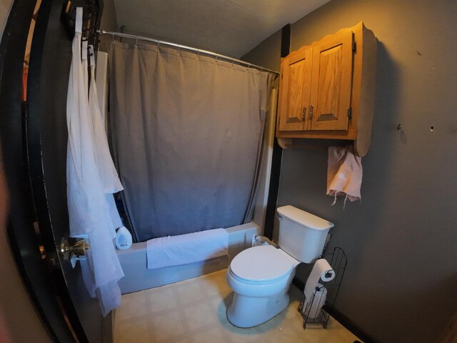 bathroom featuring toilet, tile patterned floors, and shower / tub combo