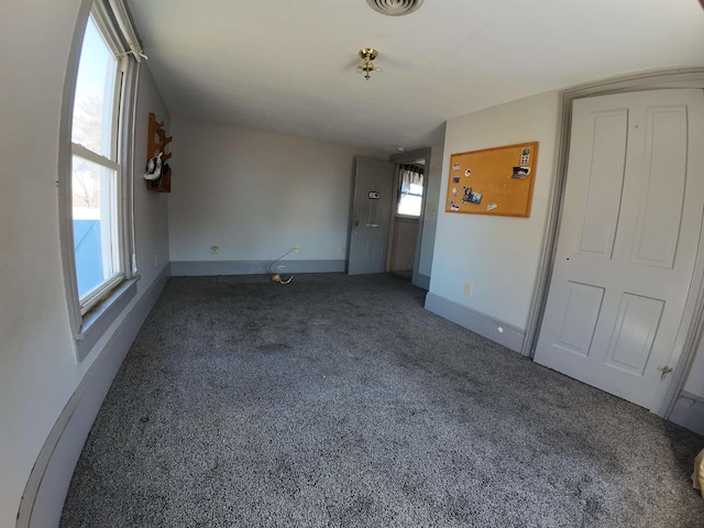 interior space featuring baseboards, carpet flooring, and visible vents