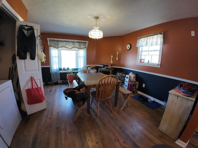 dining area featuring an inviting chandelier, washer / dryer, plenty of natural light, and wood finished floors