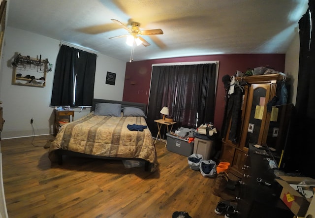 bedroom with baseboards, wood finished floors, and a ceiling fan