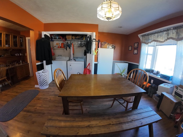dining area featuring a notable chandelier, washing machine and dryer, and wood finished floors