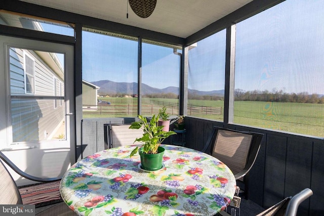 sunroom featuring a view of rural / pastoral area, healthy amount of natural light, outdoor dining space, and a mountain view