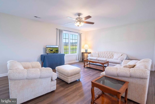 living room featuring baseboards, wood finished floors, and ceiling fan