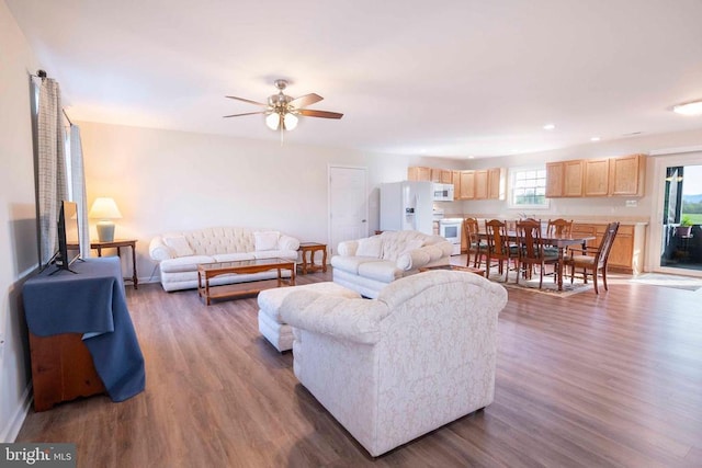 living room with wood finished floors, ceiling fan, baseboards, and recessed lighting