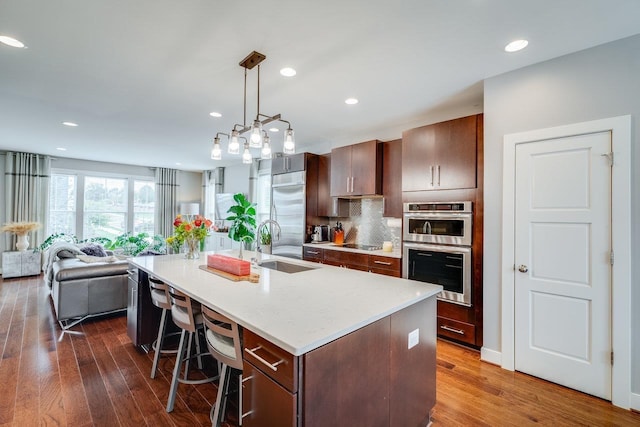 3436 Charleston Blvd, Rockingham, VA 22801 - kitchen featuring dark wood finished floors, a kitchen breakfast bar, stainless steel appliances, and a sink
