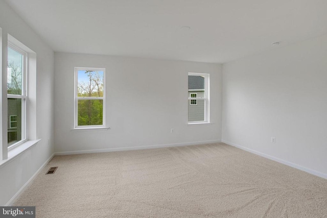 carpeted empty room featuring baseboards