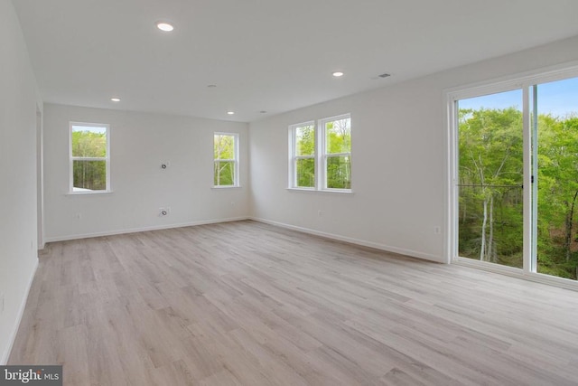 spare room with light wood finished floors, baseboards, and recessed lighting