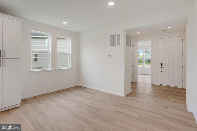 unfurnished room featuring light wood-type flooring, baseboards, and recessed lighting