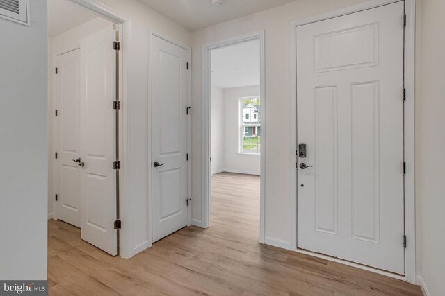 foyer featuring light wood finished floors and baseboards