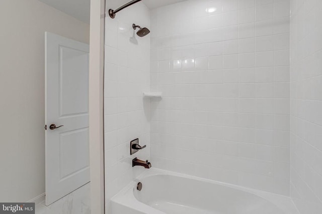 bathroom featuring shower / bath combination, marble finish flooring, and baseboards