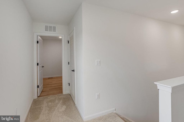 corridor featuring baseboards, light colored carpet, and recessed lighting