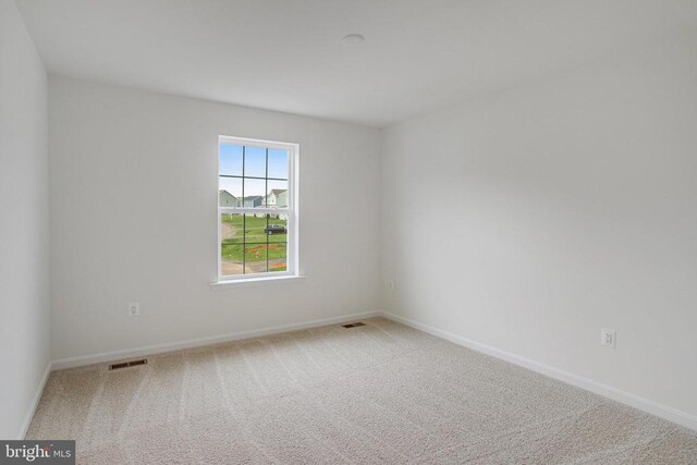 empty room featuring carpet and baseboards