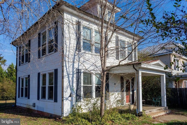 view of home's exterior featuring crawl space, fence, and a porch
