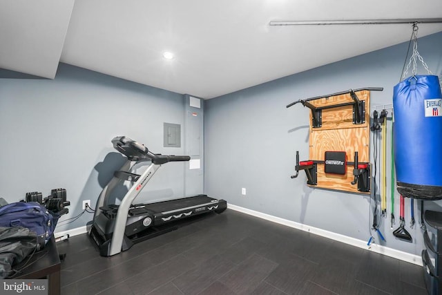 workout room featuring baseboards, recessed lighting, electric panel, and wood finished floors