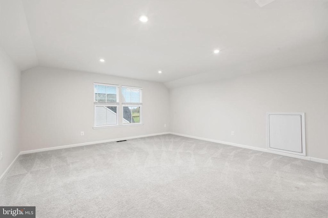 empty room with lofted ceiling, baseboards, recessed lighting, and light colored carpet