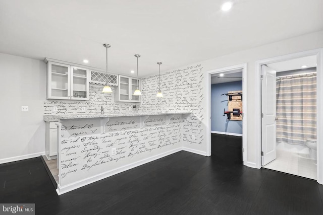 kitchen with pendant lighting, recessed lighting, glass insert cabinets, white cabinetry, and backsplash