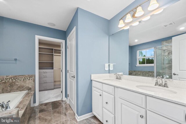 full bathroom with a stall shower, visible vents, a sink, and a walk in closet