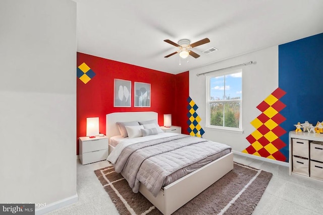 bedroom featuring visible vents, an accent wall, carpet floors, a ceiling fan, and baseboards