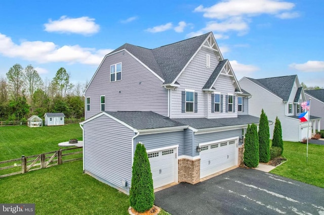 exterior space featuring a garage, fence, driveway, a front yard, and roof with shingles