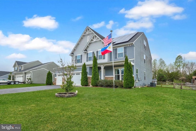 craftsman-style home featuring fence, solar panels, central AC, aphalt driveway, and a front lawn
