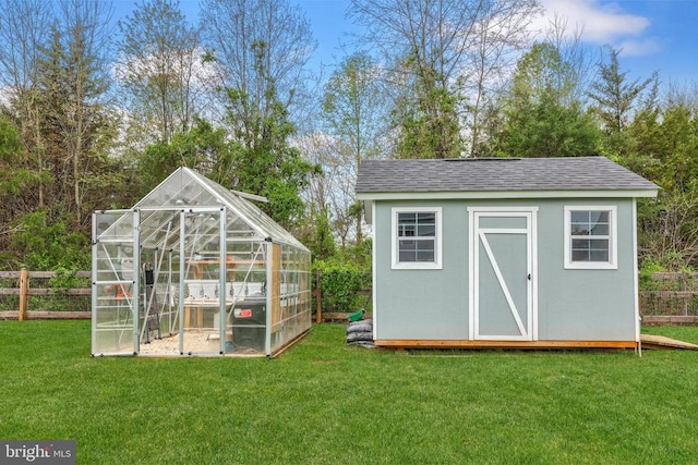 view of greenhouse featuring a yard and fence