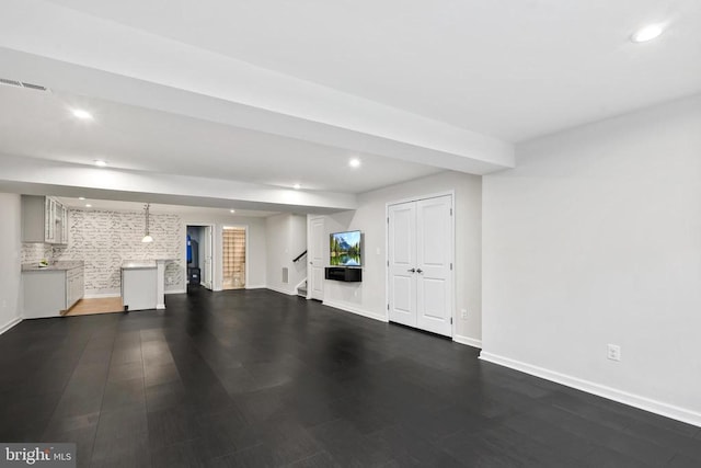 below grade area with stairs, baseboards, and recessed lighting