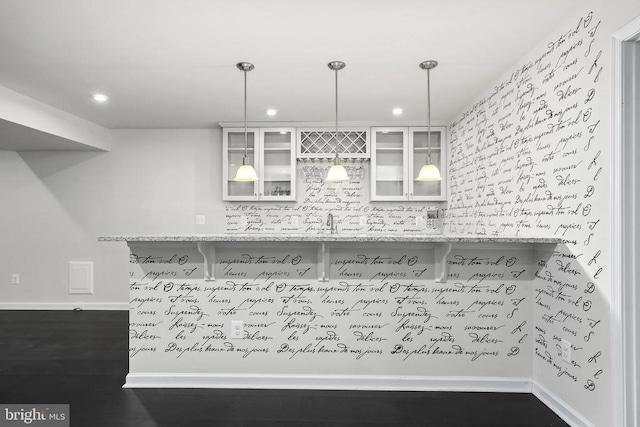 kitchen with recessed lighting, glass insert cabinets, decorative light fixtures, baseboards, and light countertops