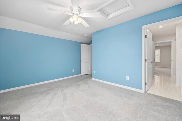 unfurnished bedroom featuring lofted ceiling, attic access, carpet floors, and baseboards