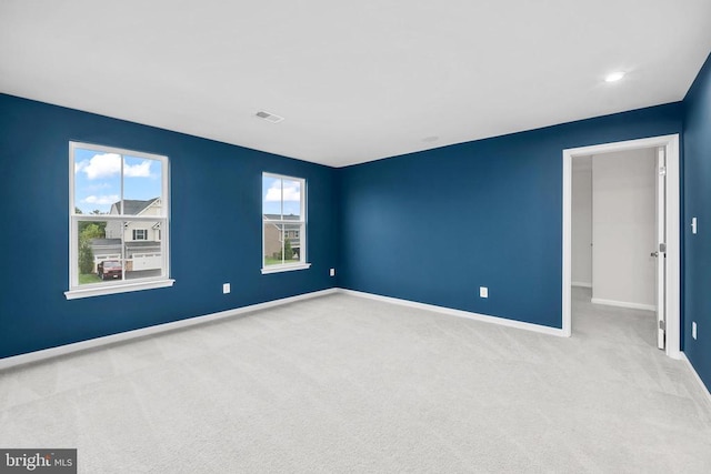 empty room with baseboards, visible vents, and carpet