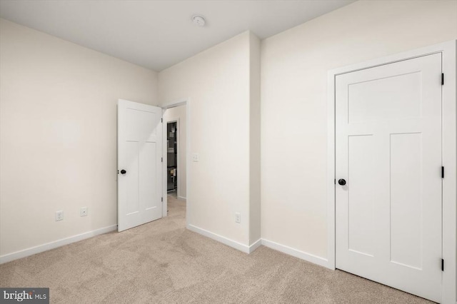 unfurnished bedroom featuring light carpet