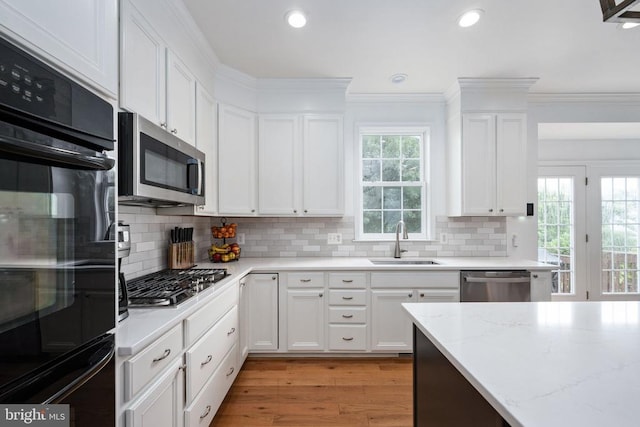 5915 Copper Mountain Dr W, Spotsylvania, VA 22553 - kitchen featuring stainless steel appliances, white cabinets, light stone counters, light wood finished floors, and tasteful backsplash